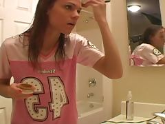 Young teen is doing make up in her bathroom using quite lots of details